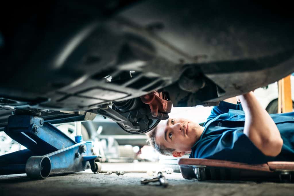 checking brakes and suspension parts during annual vehicle maintenance 